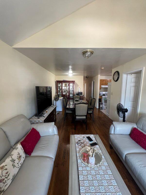 living room featuring hardwood / wood-style flooring and vaulted ceiling