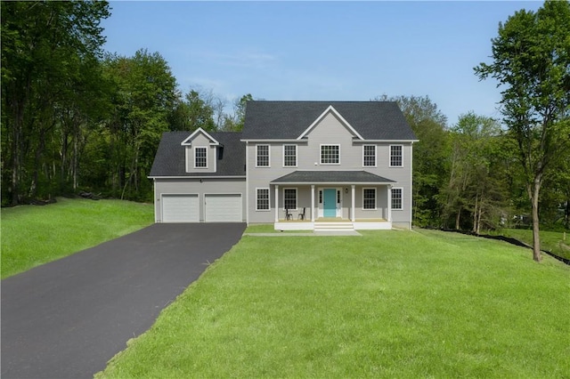 colonial-style house with a garage, covered porch, and a front yard