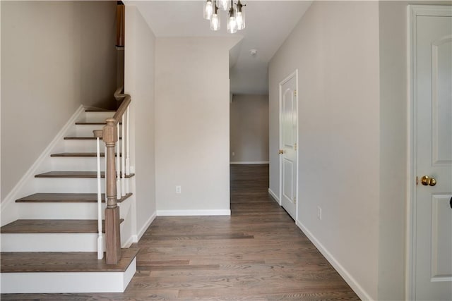 staircase featuring hardwood / wood-style flooring and a notable chandelier