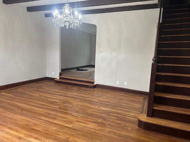 interior space featuring hardwood / wood-style floors, beamed ceiling, and a chandelier