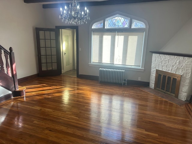 unfurnished living room featuring a fireplace, radiator heating unit, a chandelier, and dark wood-type flooring