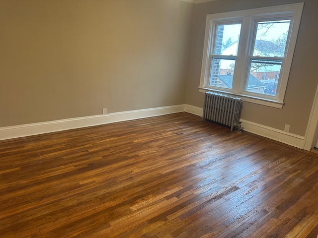 unfurnished room featuring dark hardwood / wood-style floors and radiator