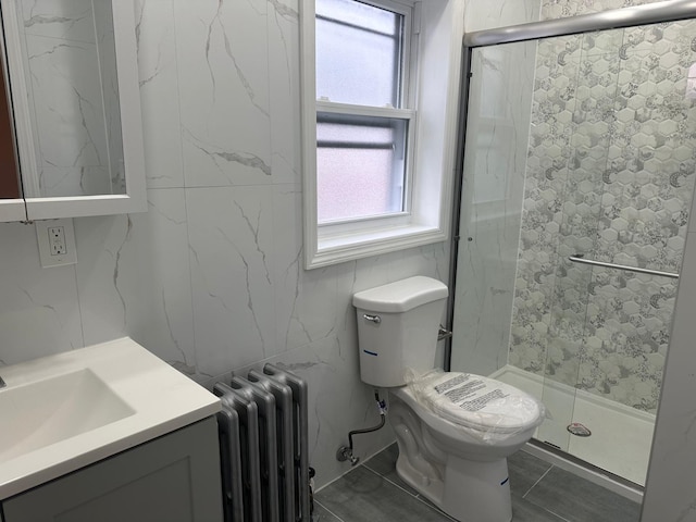 bathroom featuring a wealth of natural light, radiator heating unit, vanity, and toilet