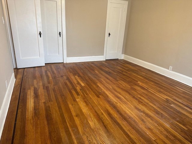 unfurnished bedroom with dark hardwood / wood-style flooring