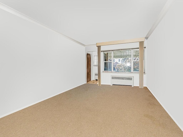 spare room featuring radiator, carpet floors, and ornamental molding