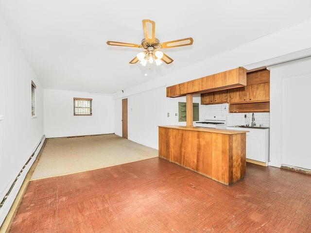 kitchen with white range, a baseboard heating unit, kitchen peninsula, decorative backsplash, and white cabinets