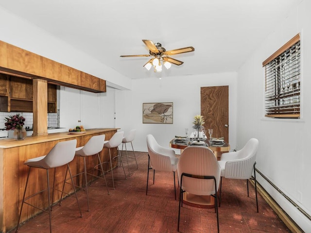 dining area with ceiling fan, dark wood-type flooring, and a baseboard radiator