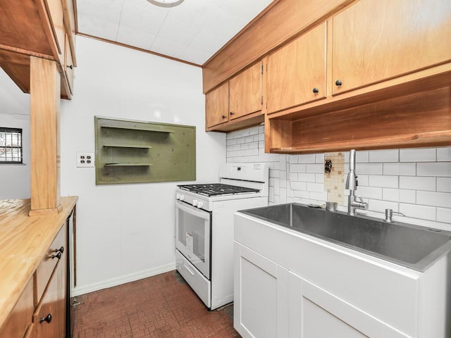 kitchen featuring decorative backsplash, gas range gas stove, and sink