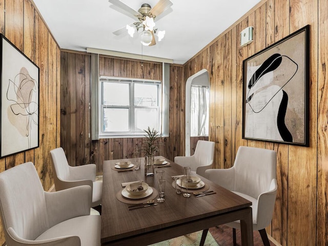 sitting room with wood walls and ceiling fan