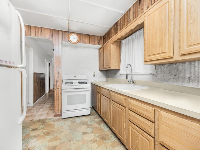 kitchen with light tile patterned flooring, white appliances, tasteful backsplash, and sink