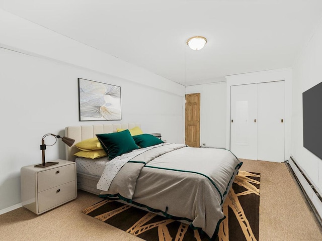 bedroom featuring light carpet, a closet, and a baseboard heating unit