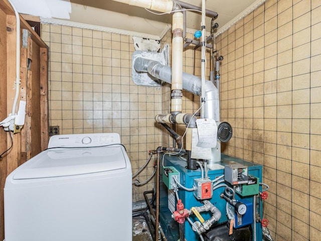 laundry area featuring washer / dryer, tile walls, and crown molding