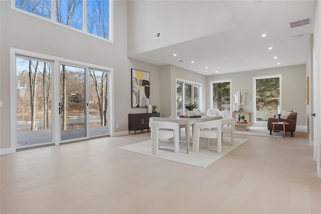 dining space with a healthy amount of sunlight and a towering ceiling