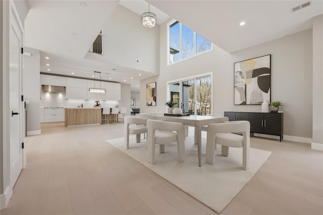 dining space with a towering ceiling and a notable chandelier