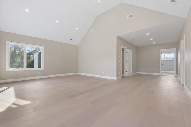 unfurnished living room with high vaulted ceiling, plenty of natural light, and light hardwood / wood-style floors