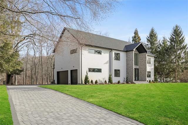 view of front of property featuring a garage and a front lawn