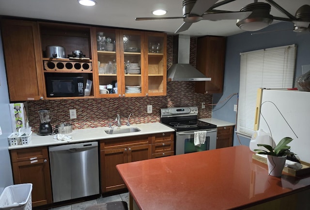 kitchen with ceiling fan, sink, wall chimney exhaust hood, decorative backsplash, and appliances with stainless steel finishes