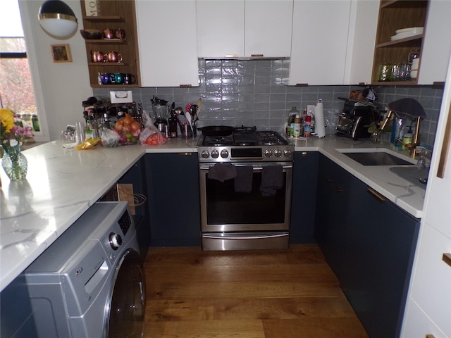 kitchen featuring stainless steel stove, dark hardwood / wood-style floors, light stone countertops, washer / dryer, and white cabinetry