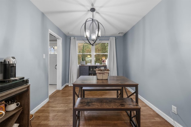 dining room with hardwood / wood-style flooring and a chandelier