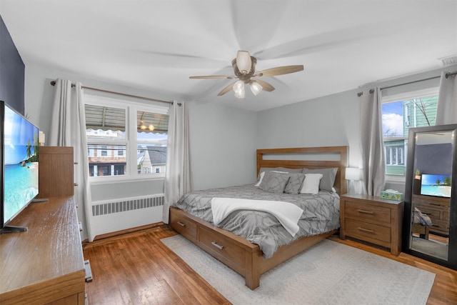 bedroom featuring radiator heating unit, ceiling fan, and hardwood / wood-style floors