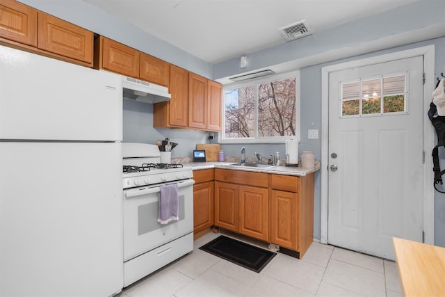 kitchen with sink, light tile patterned flooring, and white appliances