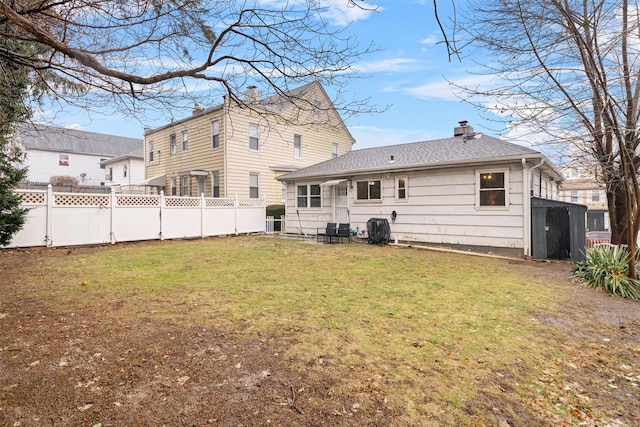 rear view of property with a yard