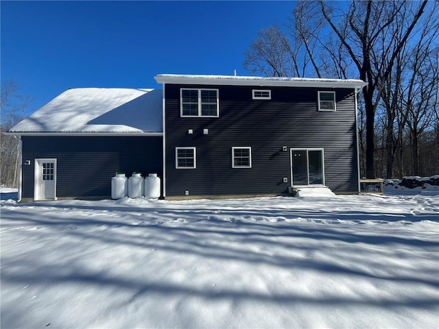 view of snow covered rear of property