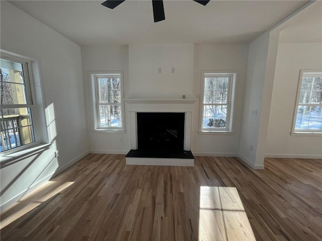 unfurnished living room with dark hardwood / wood-style floors and ceiling fan