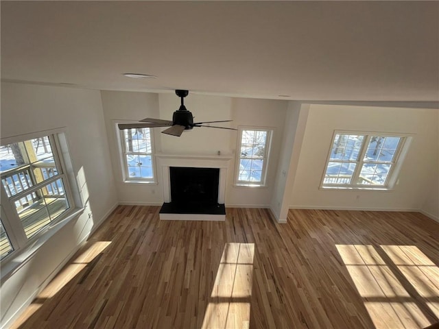 unfurnished living room with wood-type flooring and ceiling fan