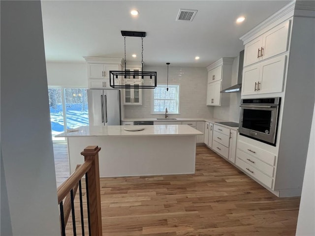 kitchen with a center island, sink, stainless steel appliances, and light hardwood / wood-style flooring