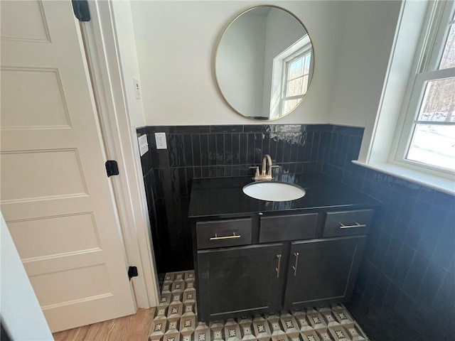 bathroom featuring hardwood / wood-style floors, vanity, and tile walls