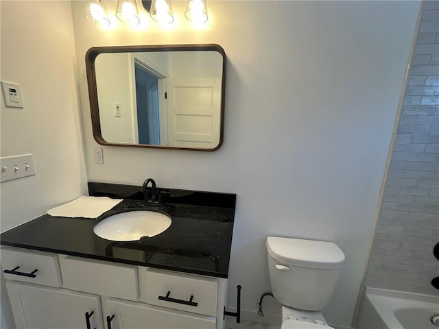 full bathroom with tiled shower / bath, vanity, and toilet