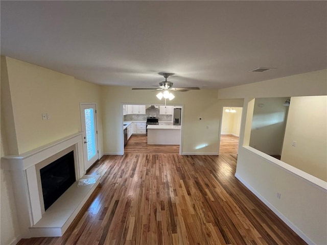 unfurnished living room with hardwood / wood-style floors and ceiling fan