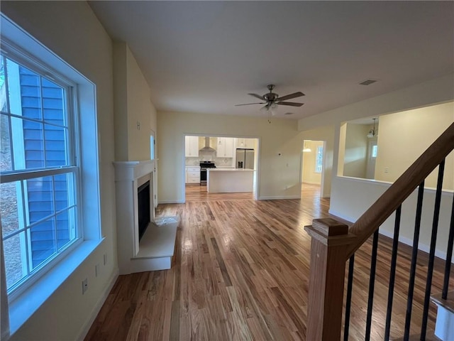 unfurnished living room with hardwood / wood-style flooring and ceiling fan