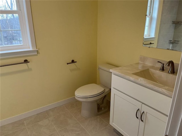 bathroom featuring tile patterned flooring, vanity, plenty of natural light, and toilet