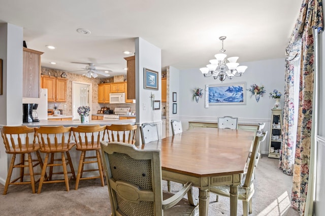 dining room with light carpet and ceiling fan with notable chandelier