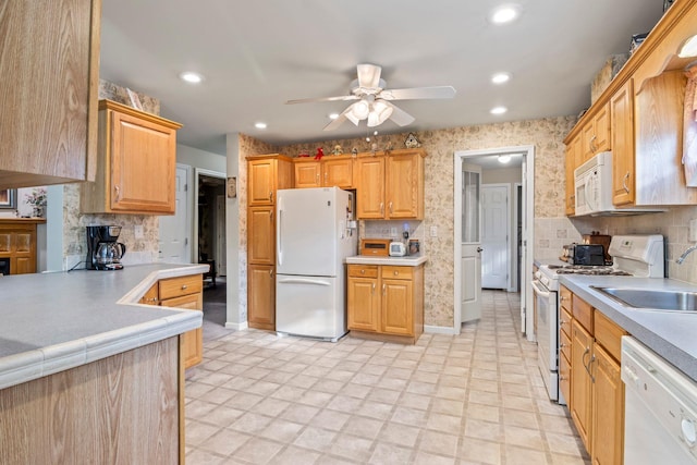 kitchen featuring white appliances, ceiling fan, and sink