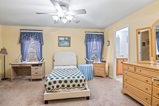 bedroom with ceiling fan, light carpet, and connected bathroom