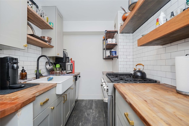 kitchen with dark hardwood / wood-style floors, decorative backsplash, appliances with stainless steel finishes, and wooden counters