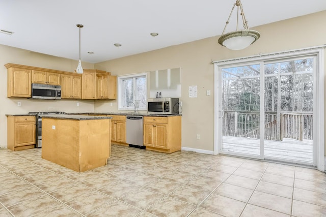 kitchen featuring stainless steel appliances, sink, pendant lighting, light tile patterned floors, and a center island