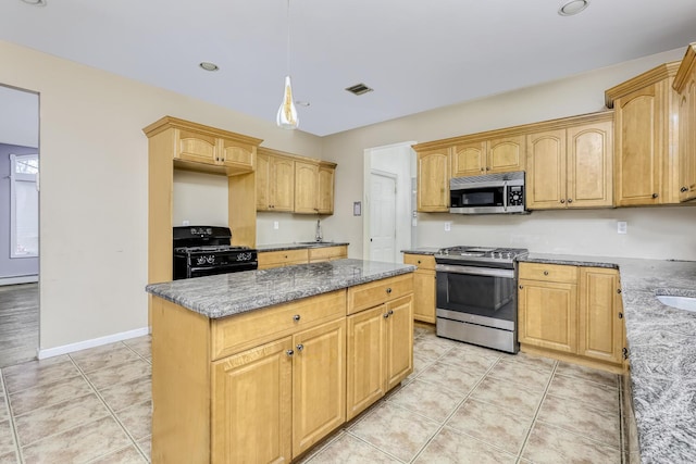 kitchen featuring light brown cabinets, stainless steel appliances, light stone counters, decorative light fixtures, and a kitchen island