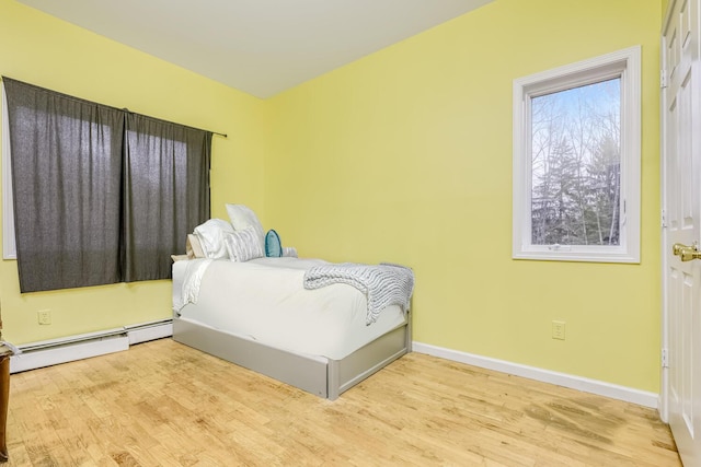 bedroom featuring light hardwood / wood-style floors and a baseboard heating unit