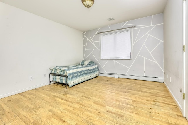 unfurnished bedroom with light wood-type flooring and a baseboard radiator