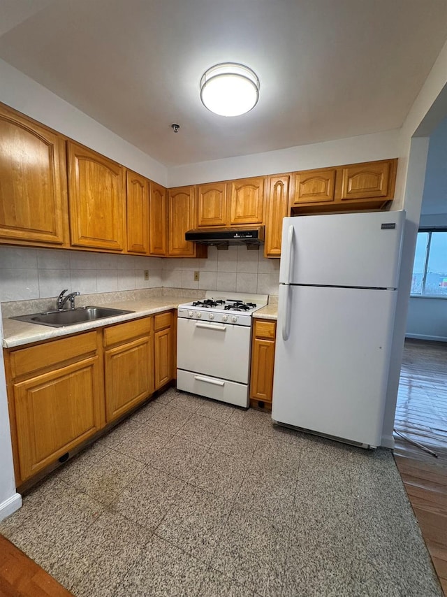 kitchen with white appliances, sink, and tasteful backsplash