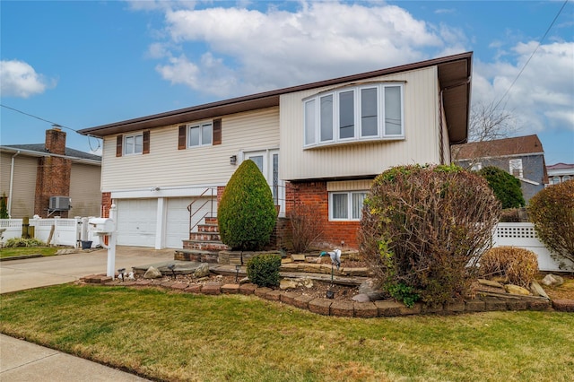 bi-level home with a garage and a front lawn
