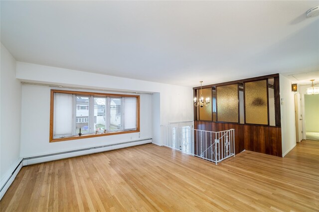 unfurnished room featuring a chandelier, a baseboard radiator, and wood-type flooring