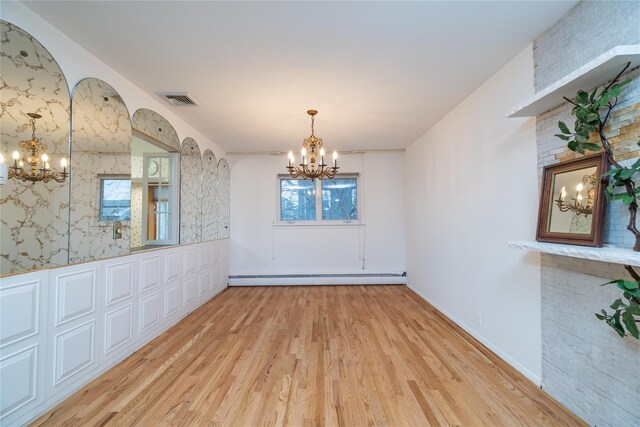 unfurnished dining area featuring a baseboard radiator, light hardwood / wood-style floors, and a notable chandelier
