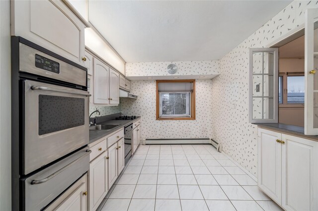 kitchen with light tile patterned floors, a baseboard radiator, oven, and sink