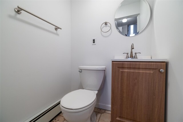 bathroom with tile patterned floors, vanity, toilet, and a baseboard heating unit