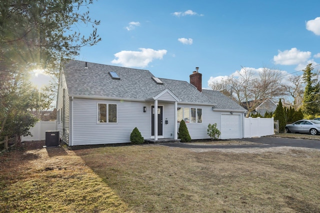 view of front facade featuring a garage, a front yard, and central AC